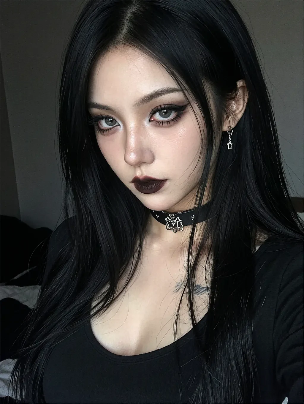 Fictional AI character with dark lipstick and a choker against a plain dark wall